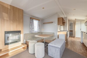 A compact living space with a kitchenette, a seating area with a table, and a built-in oven.