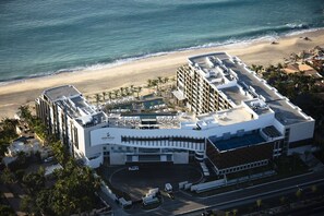 A modern hotel with a rooftop pool, a beach view, and a parking area. - Cancun - Junior Studio, Garden View, 1-King, Discounted 20-30% (Cancun)