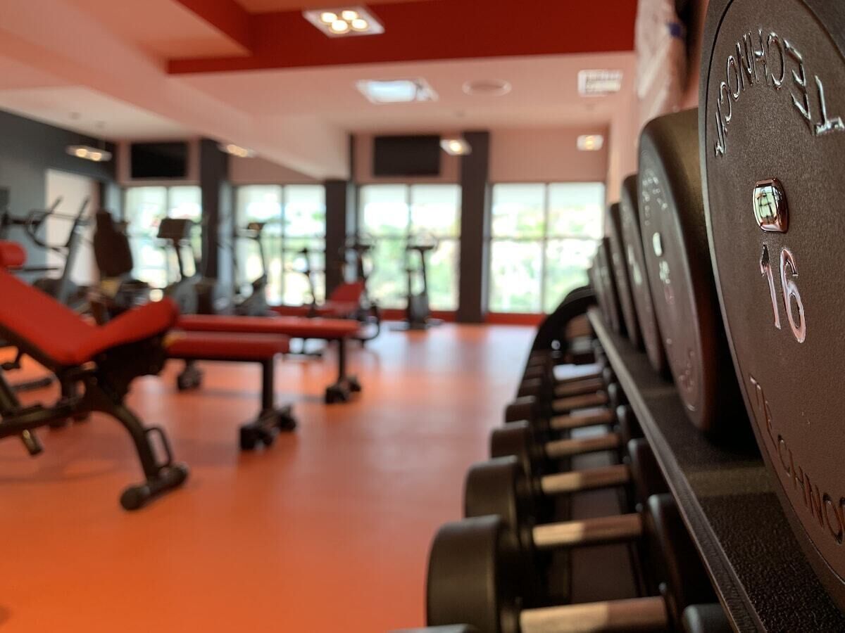 Une salle de sport équipée de matériel d’exercice et de bancs.