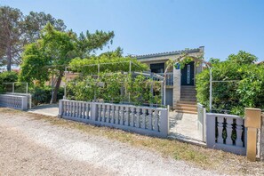 Stunning two-story building with a charming entrance and balcony, set amidst lush greenery.