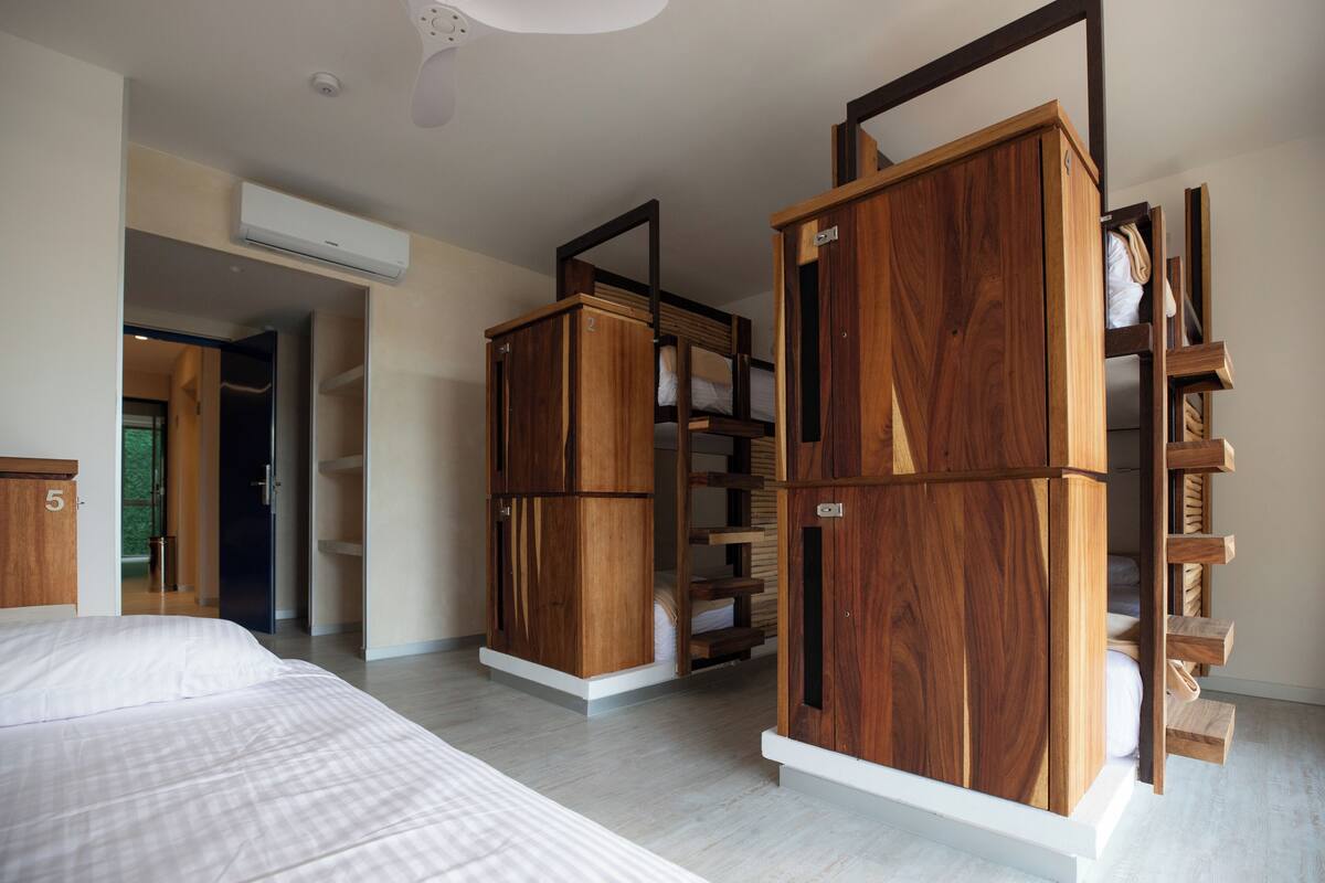 Een slaapkamer met een bed, houten kasten en een inbouwkast.