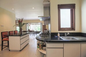 Enjoy cooking in this well-equipped kitchen with a central island, sink, and stove.