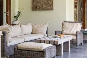 Relax in a serene outdoor space with a wicker sofa, armchair, and coffee table.