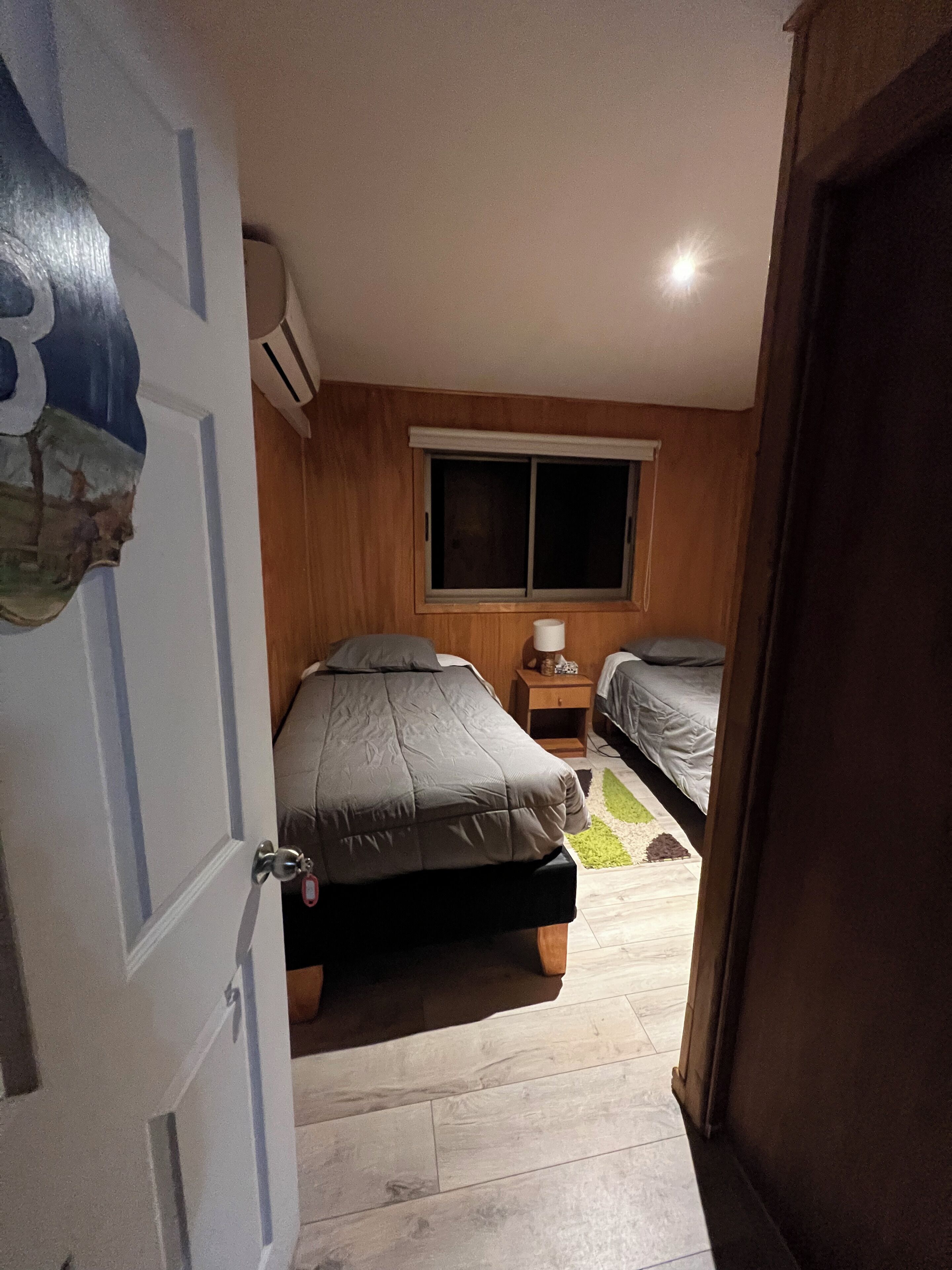 Une chambre à coucher avec un lit, une fenêtre et une table de chevet.