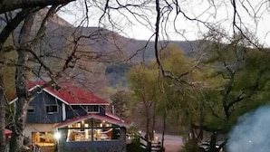 Een huis met twee verdiepingen, een rood dak, een zwembad en een terras.