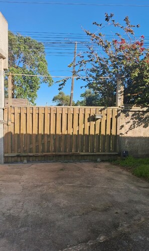 A wooden gate with a concrete wall behind it. - Refúgio Farol Ponta do Catalão - SC (Imbituba)