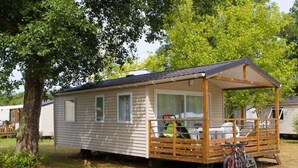 A mobile home with a covered porch and a bicycle parked outside. - ZEcamping 4* piscine couverte toboggans locatif 36m2 6 pers (Névez)