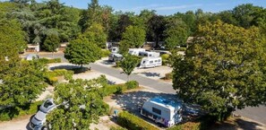 Escape to a serene camping retreat surrounded by lush greenery and well-maintained lawns.