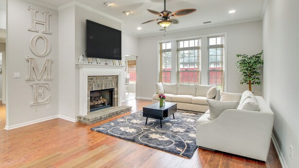 A living room with a fireplace, a sofa, a coffee table, and a ceiling fan. - 3 Mi to Oglethorpe Mall: Home w/ Fenced Yard! (Savannah)
