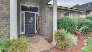 A house entrance with a welcome sign, a door, and a porch with a bench and potted plants. - 3 Mi to Oglethorpe Mall: Home w/ Fenced Yard! (Savannah)
