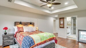 A bedroom with a bed, a nightstand, a ceiling fan, and a view of a bathroom. - 3 Mi to Oglethorpe Mall: Home w/ Fenced Yard! (Savannah)