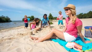 A beach scene with people engaged in activities like building sandcastles and playing.