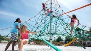 A playground with a climbing structure and slides.