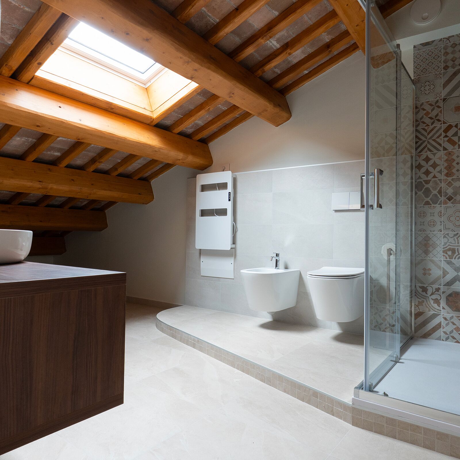 Une salle de bain moderne dotée d’une lucarne, d’une baignoire sur pieds, d’une douche à parois de verre et d’un plafond en bois.