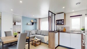 Un appartement moderne comprenant un espace de vie, un coin repas et une kitchenette.