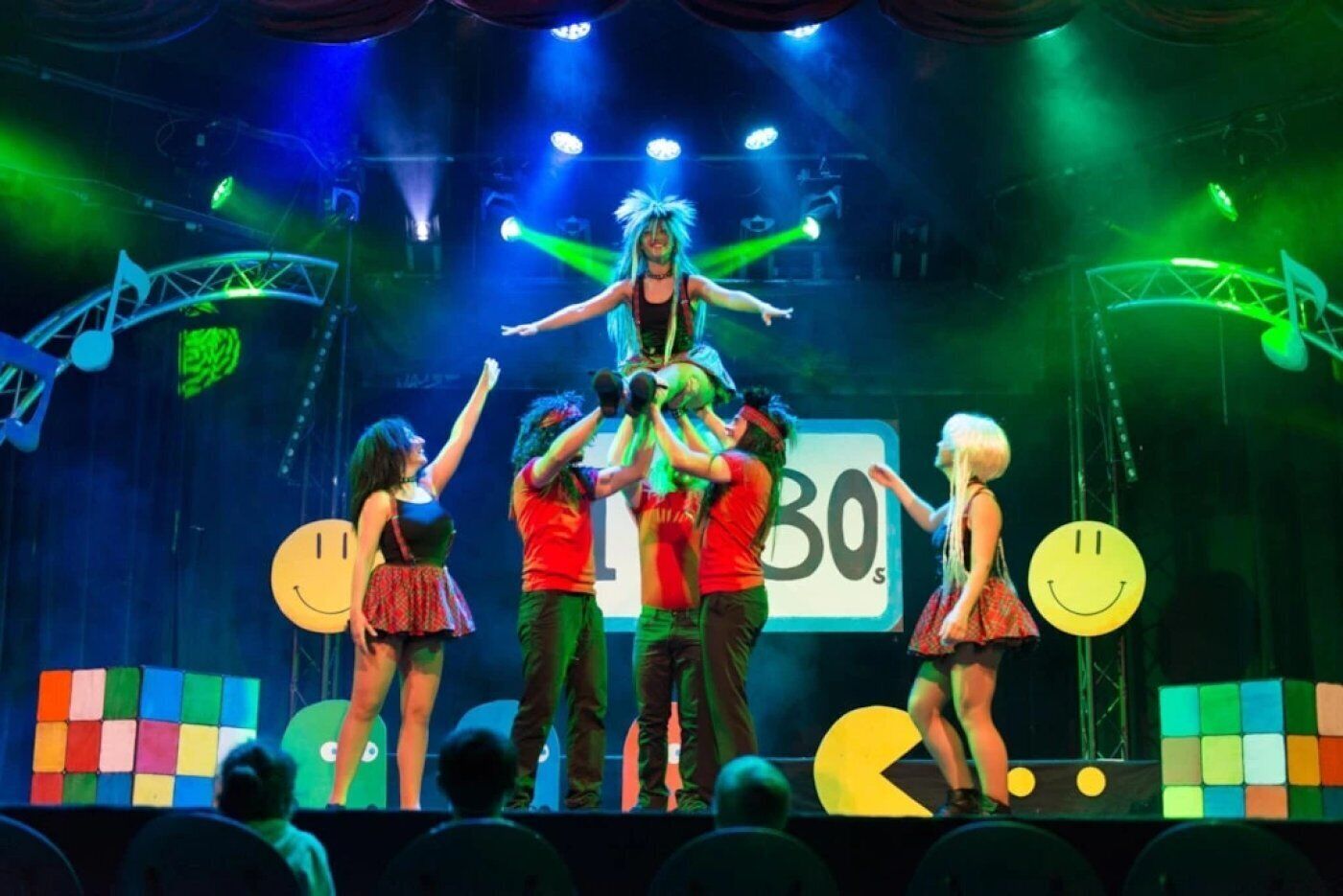 A stage with performers, a large '30s' sign, and a grid of colorful squares.