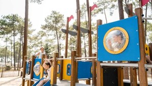 A playground with wooden play structures and slides.