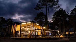 A modern building with a glass facade and an outdoor seating area.