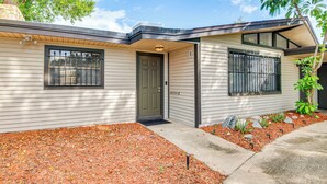 A modern two-story house with a front porch, a door, and a window with a metal grill. - 2 Mi to Cocoa Riverfront Park: Home w/ Patio! (Cocoa)