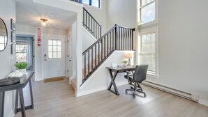 Un vaste espace de vie comprenant un escalier, une table à manger et un bureau.