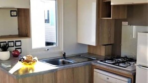 Una cocina moderna con armarios de madera, lavavajillas integrado y cocina a gas.
