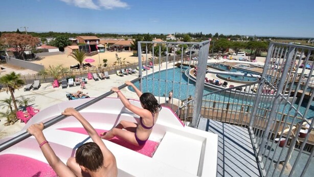 Ein Poolbereich mit Sprungbrett, Liegestühlen und Blick auf die umliegende Landschaft.