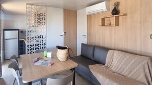 A modern interior with a dining area, sofa, and kitchenette.