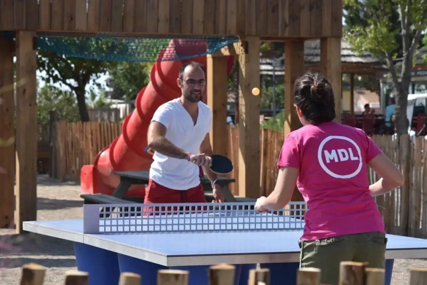 A table tennis table with a net in an outdoor setting.