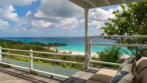A balcony with a view of a beach and ocean.