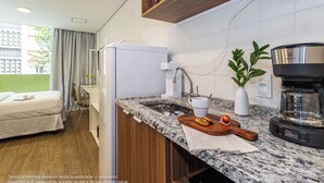 Eine moderne Küche mit einer Granit-Arbeitsplatte, einer Kaffeemaschine und einem kleinen Essbereich mit einem Holztisch und Stühlen.