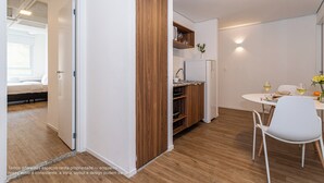 Eine moderne Küche mit Holzschränken, einem weißen Kühlschrank und einem Essbereich mit Tisch und Stühlen.