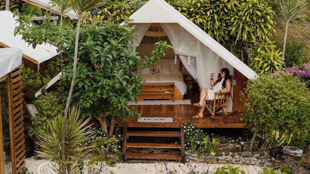 A small, elevated wooden structure with a tent-like roof, surrounded by lush greenery and plants. - Yaloco House Monteverde  (Sierra)