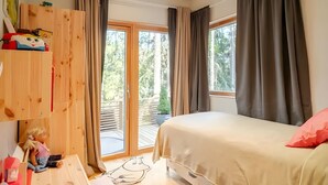 Une chambre à coucher avec un lit, une armoire en bois, une fenêtre avec des rideaux et une vue sur l’extérieur.