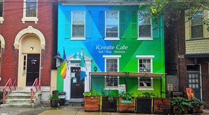 A colorful building with a sign for 'iCreate Cafe' and a rainbow flag.