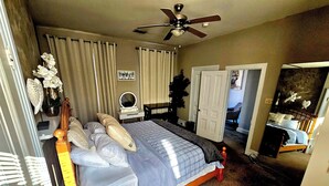 A bedroom with a bed, a dresser, a mirror, and a ceiling fan. - Loft • King Bed • Free Parking • Early Check in 2pm / 12pm Late Check Out (Pottstown)