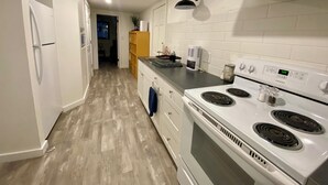 Une cuisine moderne avec des meubles blancs, une cuisinière et un four à micro-ondes.