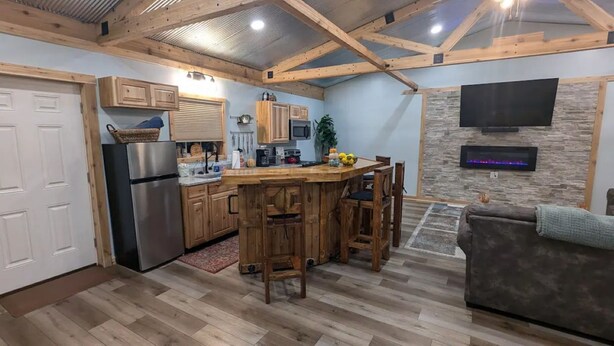 Une cuisine spacieuse avec des meubles en bois, un îlot central et un téléviseur encastré.