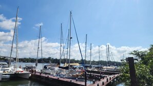 A marina with multiple sailboats docked at wooden piers.