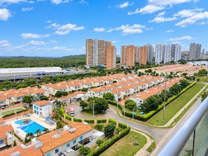 A residential area with multiple-story buildings, a swimming pool, and well-maintained green spaces.