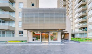 A modern building with a flat roof, large windows, and a central entrance with a glass door.