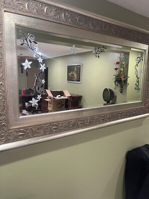 Un miroir avec un cadre orné, une décoration murale et un tableau encadré.