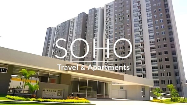 A modern building with multiple floors, a flat roof, and a sign indicating it is a travel and apartment complex. - Apartamentos Mirador - by SOHO (Puerto Colombia)