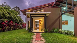 Een modern huis met een verzorgd gazon, een pad naar de ingang en een zichtbare deur.