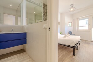 Un dormitorio moderno con cama, mesita de noche y un espejo grande.