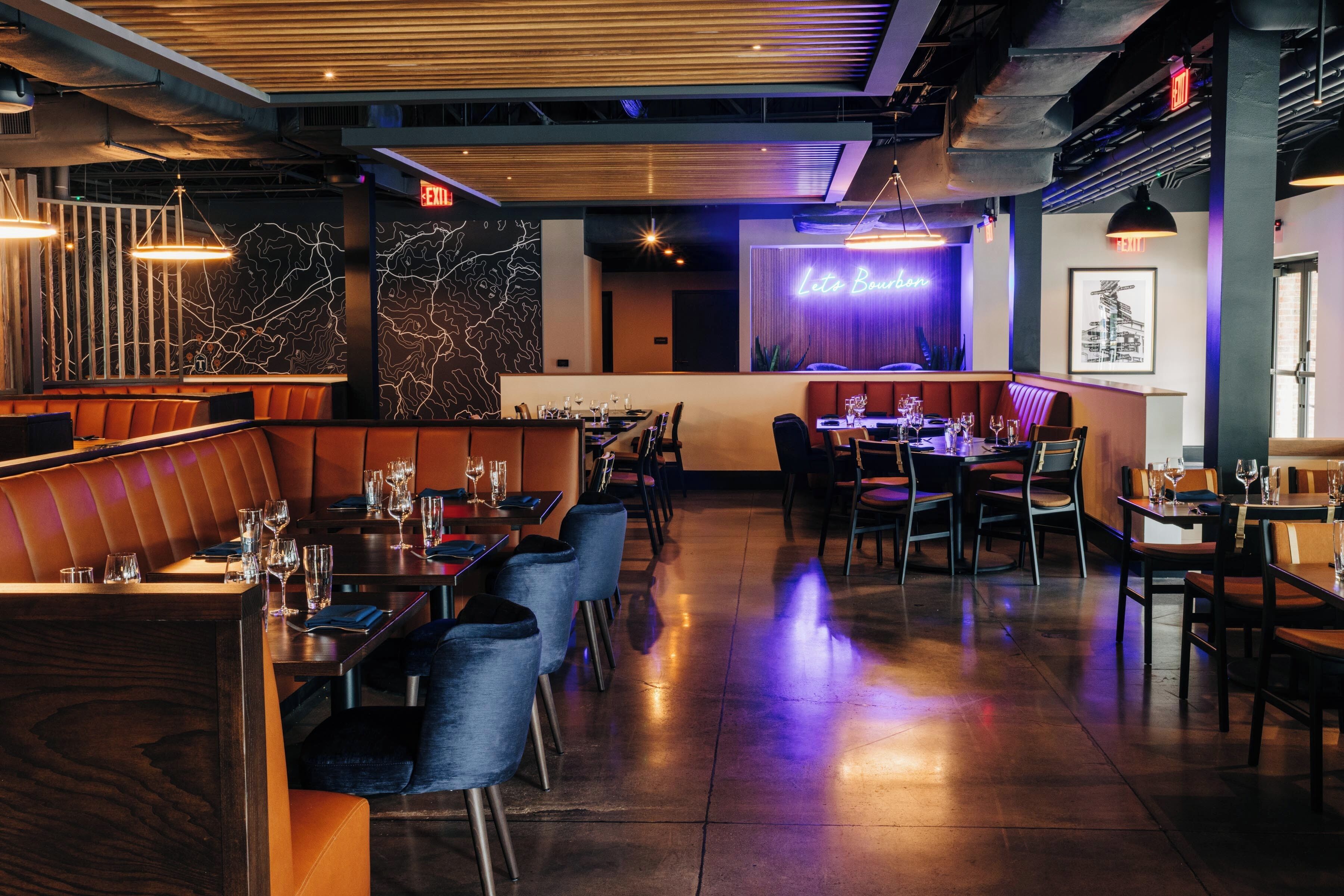 A restaurant interior with booths, tables, and a neon sign reading "Leito Boucher".