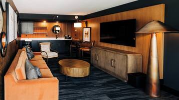 A modern living room with a sofa, coffee table, and a TV mounted on the wall.