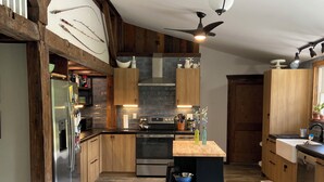 Una cocina moderna con armarios de madera, una isla central y un suelo con patrón de espiga.
