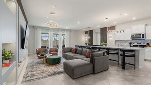 A modern living room with a sectional sofa, a coffee table, and a TV mounted on the wall. - Ultimate 10 Bed Luxury Retreat With Epic Playroom (Clermont)