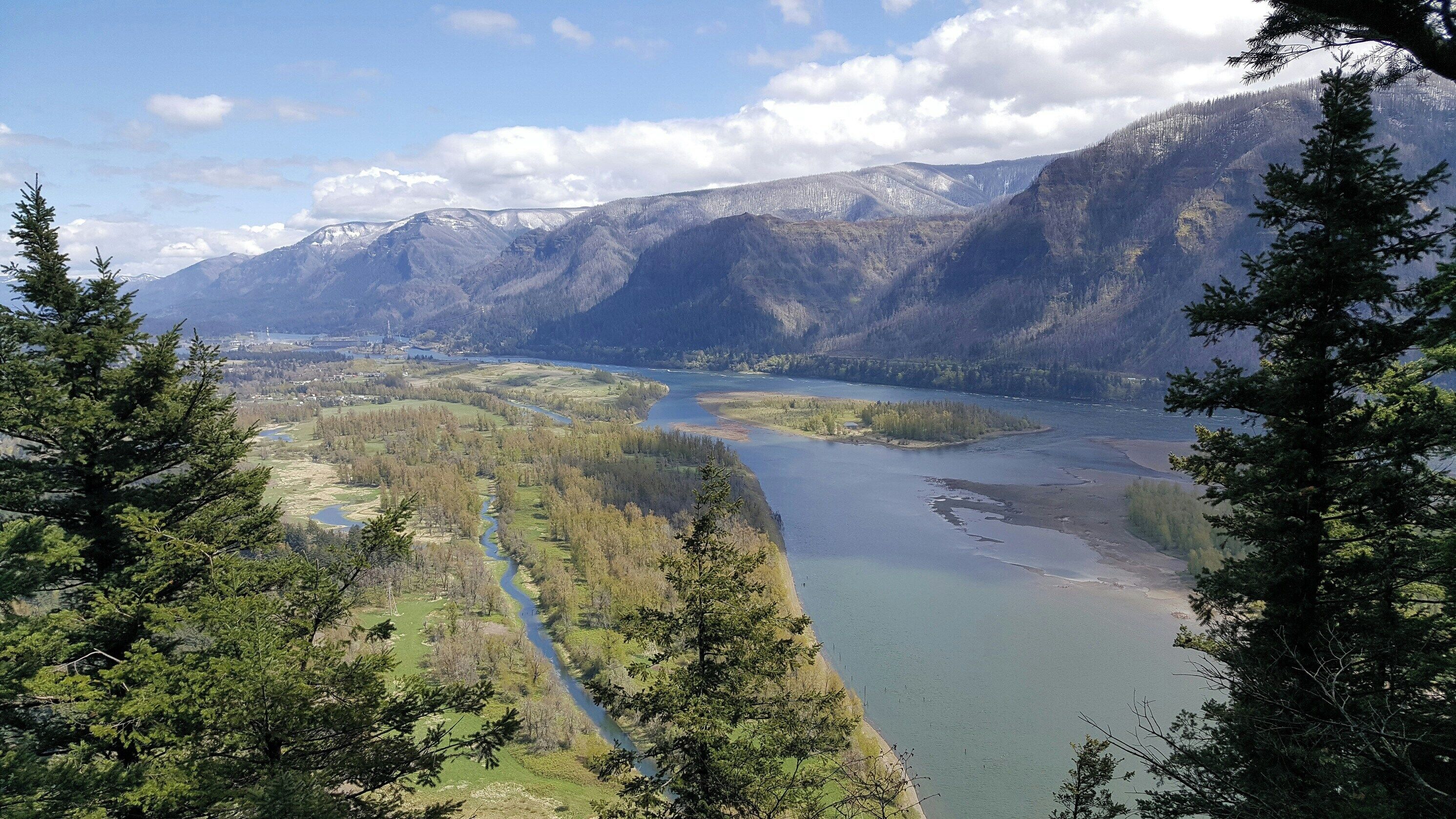 A river winding through a valley with mountains in the background.