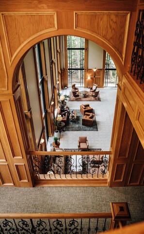 Un amplio salón con paneles de madera, ventanas grandes y vistas al exterior.